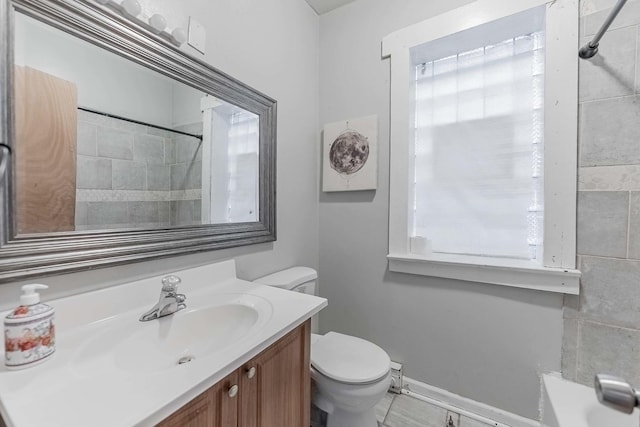 bathroom with baseboards, a shower, toilet, vanity, and a bath