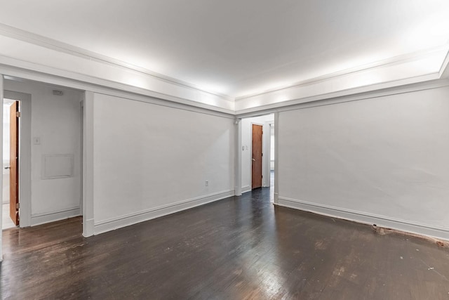 spare room with baseboards and wood finished floors