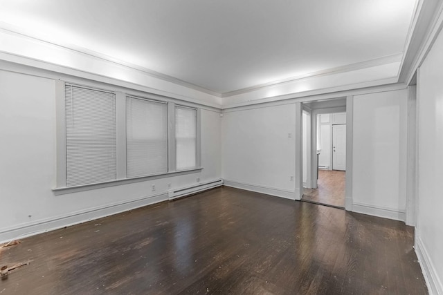 spare room featuring a baseboard heating unit, ornamental molding, baseboards, and wood finished floors