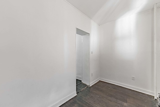 empty room featuring dark wood-type flooring and baseboards