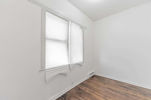 unfurnished room with baseboards and wood finished floors