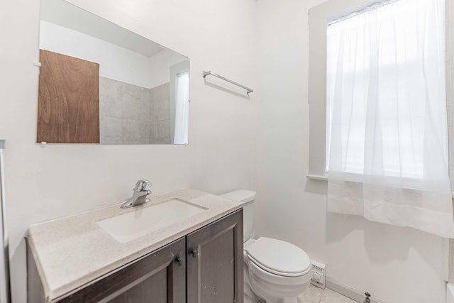 bathroom featuring tile patterned floors, vanity, toilet, and a healthy amount of sunlight