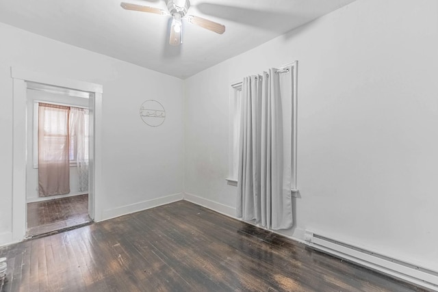 empty room featuring a ceiling fan, baseboard heating, hardwood / wood-style flooring, and baseboards