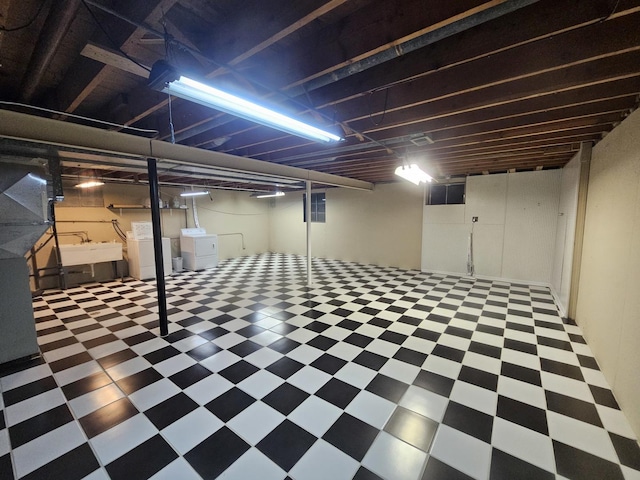 finished basement with tile patterned floors, a sink, and independent washer and dryer