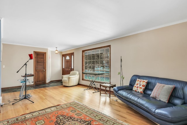 living area with crown molding, baseboards, and wood finished floors