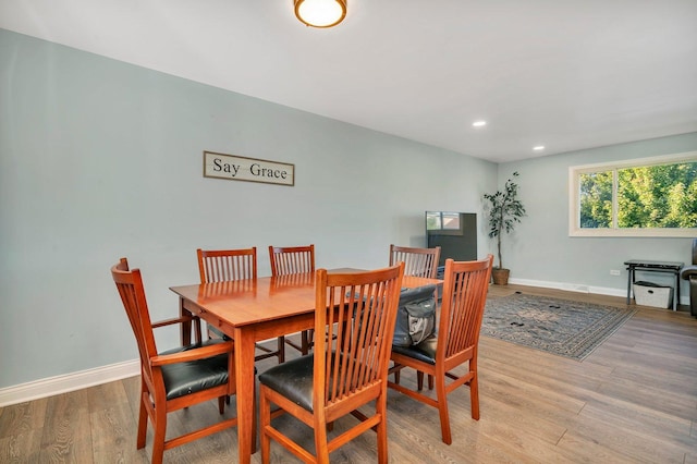 dining space featuring baseboards, wood finished floors, and recessed lighting