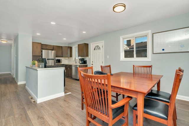 dining area with recessed lighting, light wood-type flooring, and baseboards