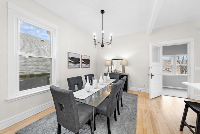 dining area with light wood-type flooring, beam ceiling, baseboards, and a chandelier