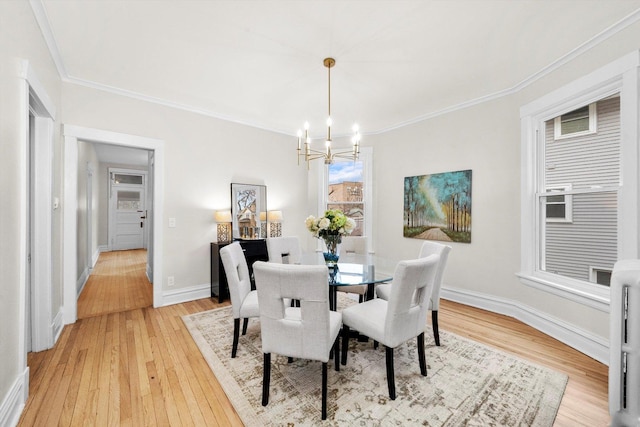 dining space with baseboards, a notable chandelier, ornamental molding, and light wood finished floors