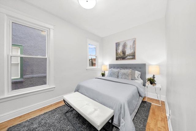 bedroom with baseboards and wood finished floors