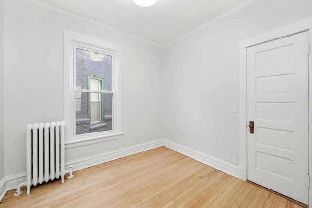 unfurnished room featuring baseboards, wood-type flooring, radiator heating unit, and ornamental molding