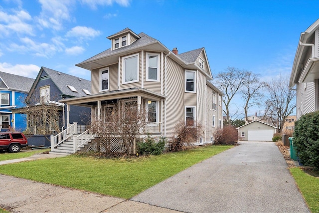 traditional style home with an outdoor structure, a garage, covered porch, and a front lawn