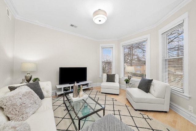 living area with visible vents, wood finished floors, and crown molding