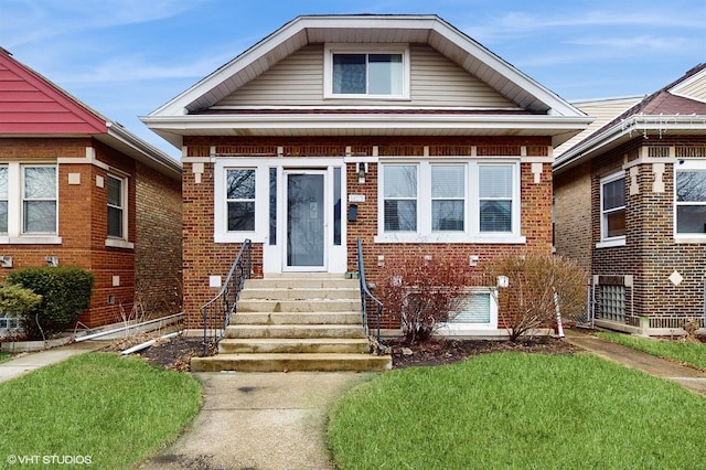 bungalow-style house featuring brick siding and entry steps