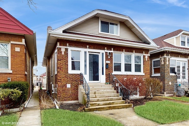 bungalow-style house with brick siding and entry steps