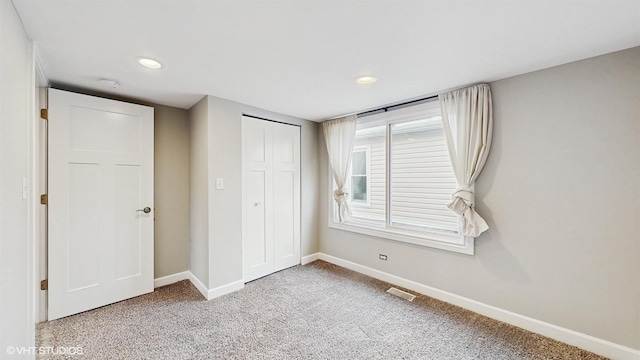 unfurnished bedroom featuring visible vents, baseboards, carpet, recessed lighting, and a closet