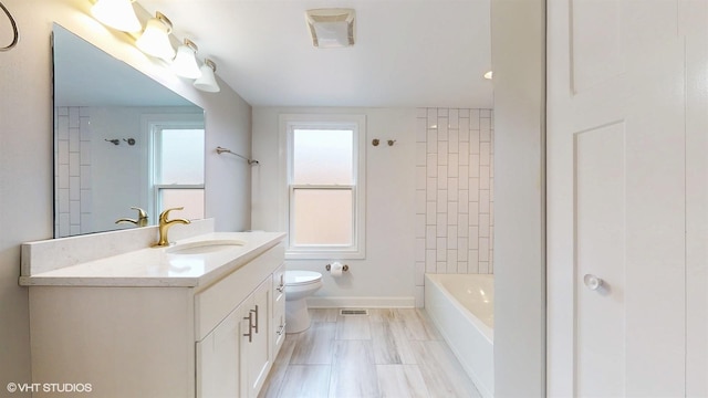 full bathroom featuring visible vents, baseboards, washtub / shower combination, toilet, and vanity