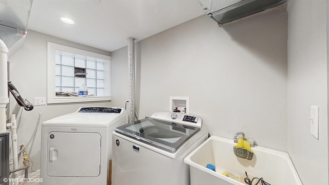 laundry room featuring a sink, washing machine and dryer, and laundry area