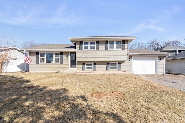 tri-level home with a garage, a front yard, and aphalt driveway