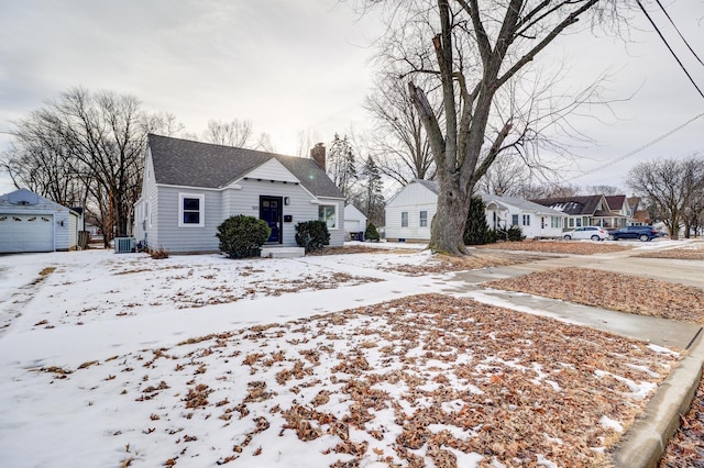 bungalow with cooling unit, a garage, an outdoor structure, a residential view, and a chimney