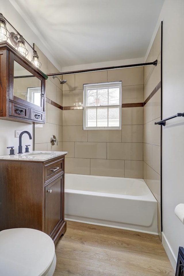 bathroom featuring washtub / shower combination, wood finished floors, and toilet