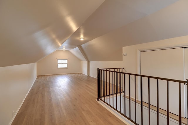 bonus room with vaulted ceiling, wood finished floors, and baseboards