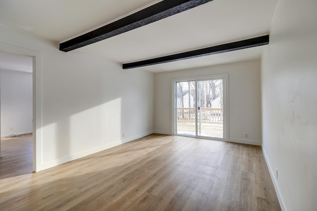 empty room featuring light wood-type flooring, beam ceiling, and baseboards