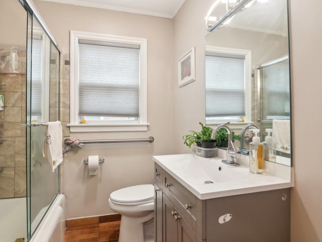 bathroom featuring toilet, a wealth of natural light, wood finished floors, and vanity