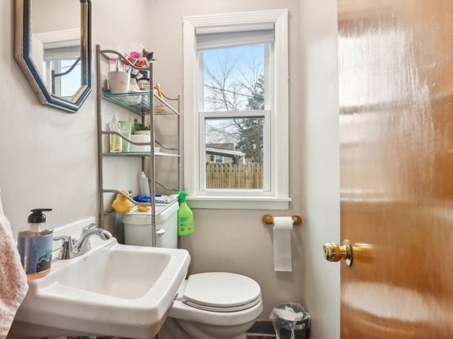 half bath with a healthy amount of sunlight, a sink, and toilet