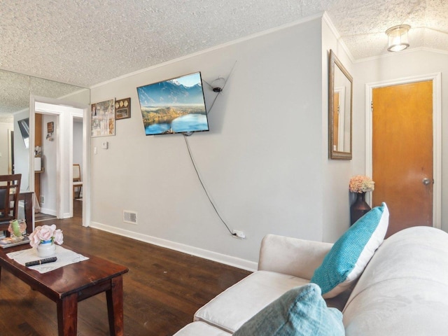 living area with ornamental molding, visible vents, a textured ceiling, and wood finished floors