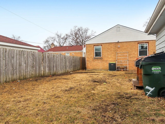 view of yard featuring fence and central AC