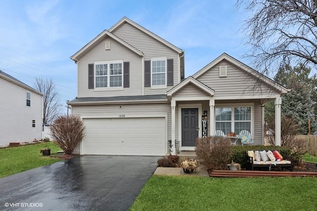 traditional home featuring a garage, driveway, and a front lawn