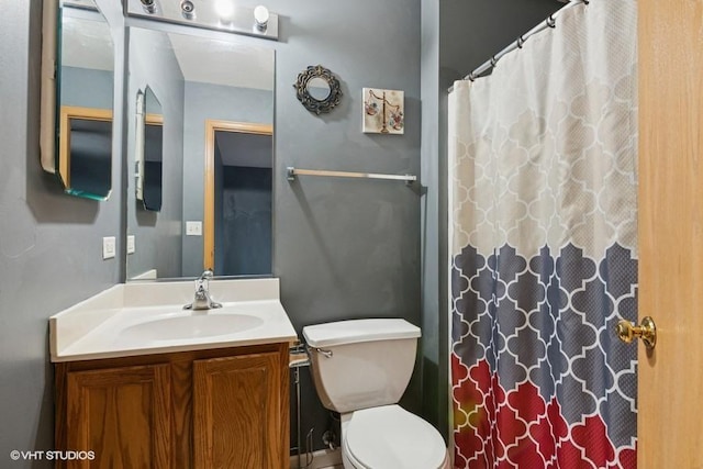 full bath with curtained shower, vanity, and toilet