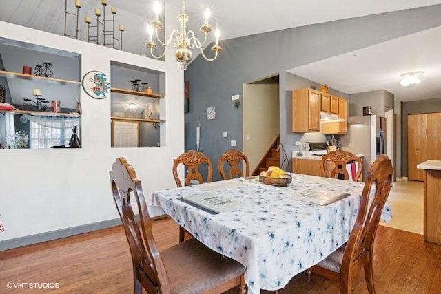 dining space with light wood-style floors, stairs, built in shelves, and a notable chandelier