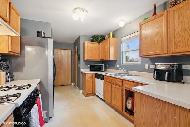 kitchen with a sink, range with gas stovetop, light countertops, dishwasher, and light floors