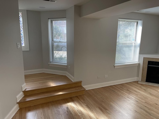 unfurnished living room featuring light wood-style floors, a fireplace, and baseboards