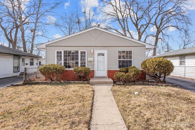 bungalow-style house featuring brick siding and a front yard