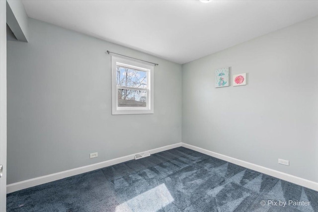 unfurnished room with visible vents, baseboards, and dark carpet