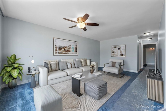 living area with a ceiling fan and baseboards