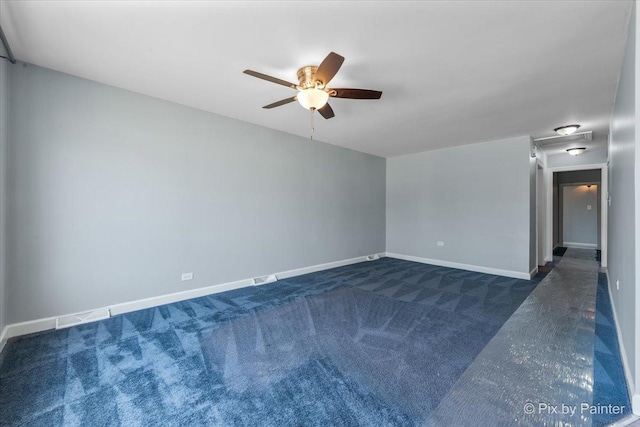 empty room with a ceiling fan, baseboards, and dark carpet