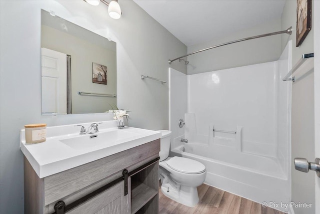 bathroom featuring vanity, toilet, shower / tub combination, and wood finished floors