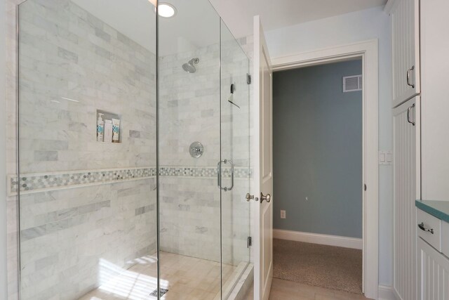 full bath with double vanity, a sink, baseboards, and wood finished floors