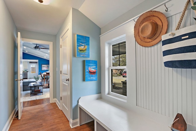 mudroom featuring a wealth of natural light, vaulted ceiling, baseboards, and wood finished floors