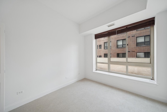 unfurnished room featuring light colored carpet, visible vents, and baseboards