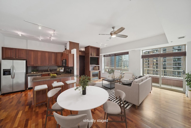 interior space featuring ceiling fan, visible vents, and wood finished floors