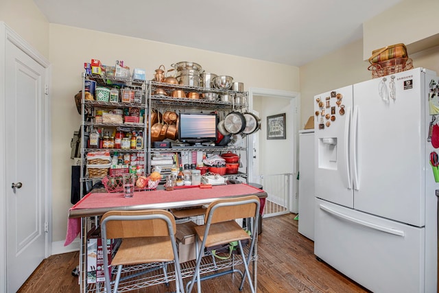 kitchen featuring white refrigerator with ice dispenser and wood finished floors