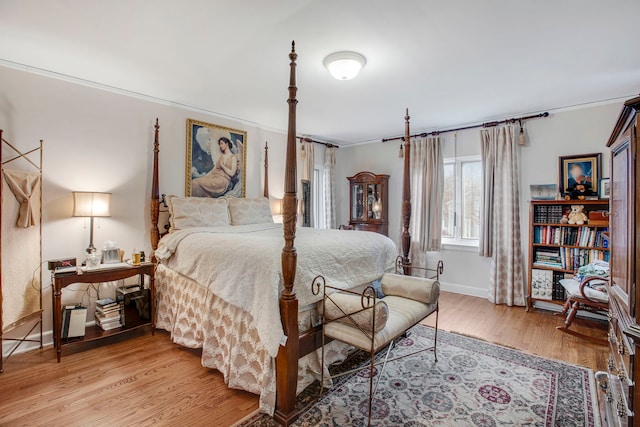 bedroom featuring light wood-style floors, baseboards, and crown molding