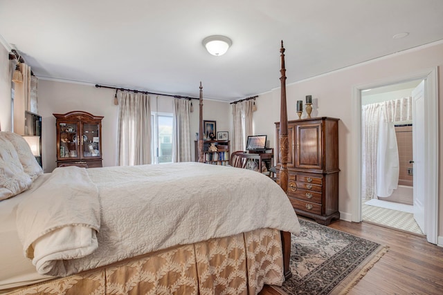 bedroom with wood finished floors and crown molding