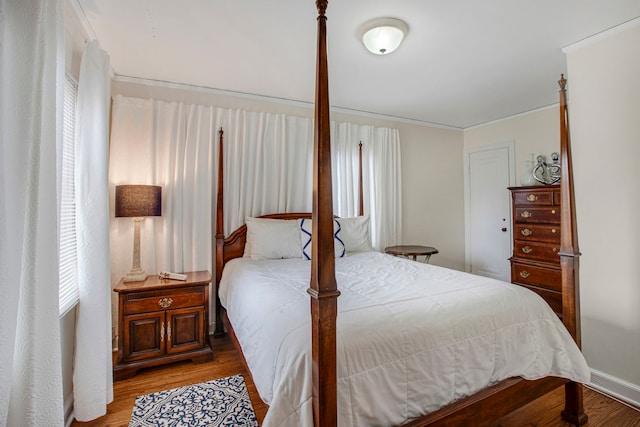 bedroom featuring crown molding and wood finished floors