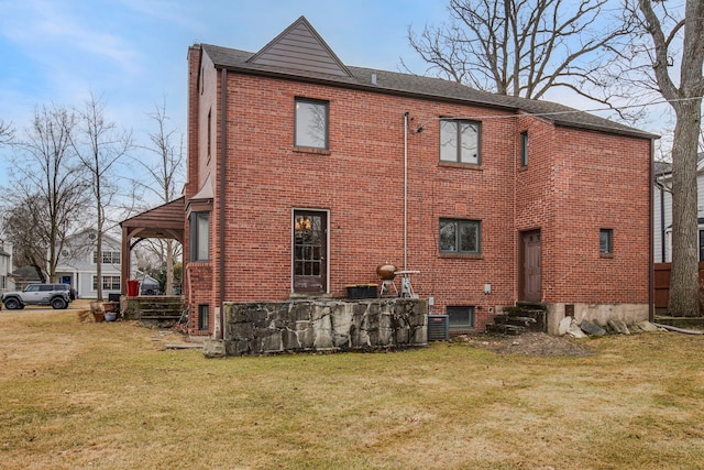 view of side of home with entry steps, a yard, brick siding, and central AC